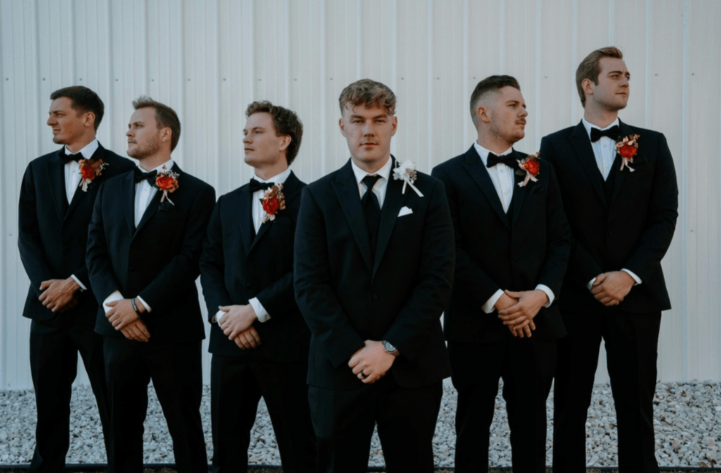 Wedding party wearing coordinated black suits before a formal celebration.